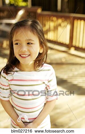 Stock Photograph - Mixed race girl smiling outdoors. Fotosearch