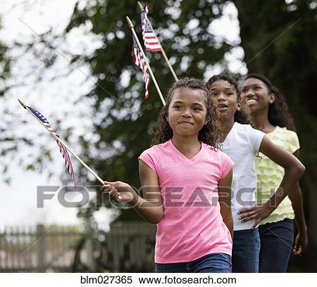 Mixed race girls marching with American flags View Large Photo Image Stock Photography - Mixed race girls marching with American flags. Fotosearch