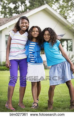 Stock Image - Mixed race girls smiling outdoors. Fotosearch