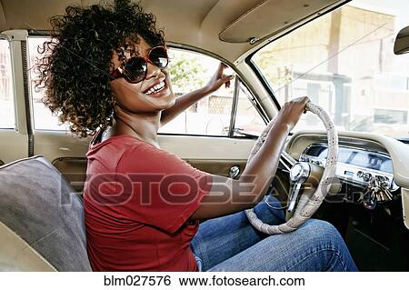 Mixed race woman driving vintage car View Large Photo Image Stock Photograph - Mixed race woman driving vintage car. Fotosearch