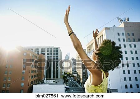 Stock Image - Mixed race woman on urban rooftop. Fotosearch