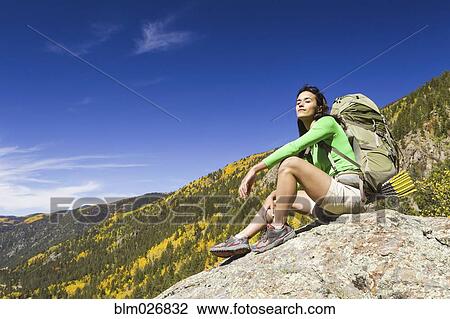 Mixed race woman sitting on rock View Large Photo Image Stock Image - Mixed race woman sitting on rock. Fotosearch