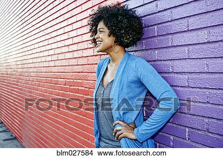 Mixed race woman standing by colorful wall View Large Photo Image Picture - Mixed race woman standing by colorful wall. Fotosearch