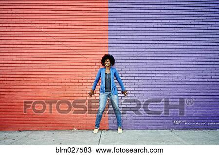 Mixed race woman standing by colorful wall View Large Photo Image Stock Image - Mixed race woman standing by colorful wall. Fotosearch