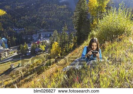 Mixed race woman taking pictures on rural hillside View Large Photo Image Stock Photo - Mixed race woman taking pictures on rural hillside. Fotosearch