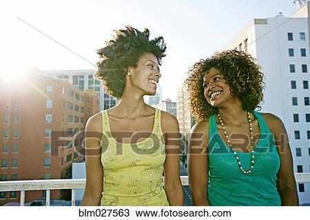 Mixed race women on urban rooftop View Large Photo Image Stock Image - Mixed race women on urban rooftop. Fotosearch