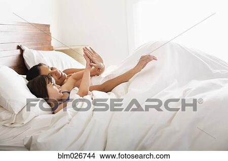 Mother and daughter laying in bed View Large Photo Image Picture - Mother and daughter laying in bed. Fotosearch