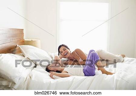 Stock Photograph - Mother and daughter laying in bed. Fotosearch