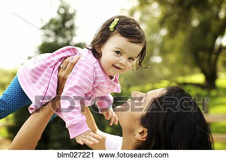 Mother holding toddler daughter View Large Photo Image Stock Image - Mother holding toddler daughter. Fotosearch