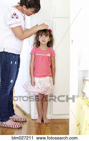 Mother measuring daughter's height View Large Photo Image Stock Image - Mother measuring daughter's height. Fotosearch