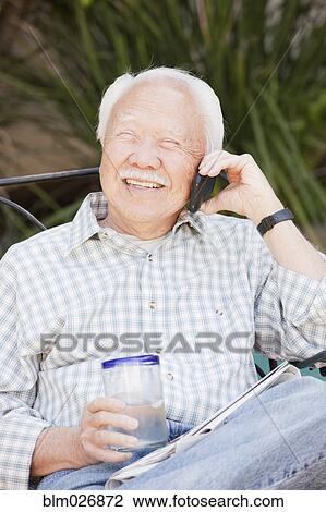 Older Asian man talking on cell phone outdoors View Large Photo Image Stock Image - Older Asian man talking on cell phone outdoors. Fotosearch
