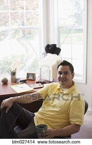 Pacific Islander businessman having coffee at desk View Large Photo Image Picture - Pacific Islander businessman having coffee at desk. Fotosearch