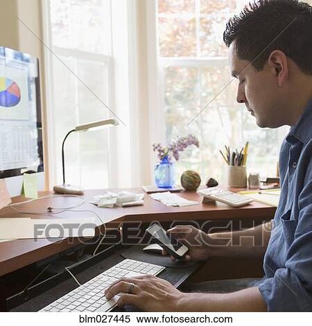 Stock Photography - Pacific Islander businessman working at desk. Fotosearch