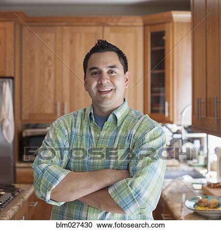 Stock Image - Pacific Islander man smiling in kitchen. Fotosearch