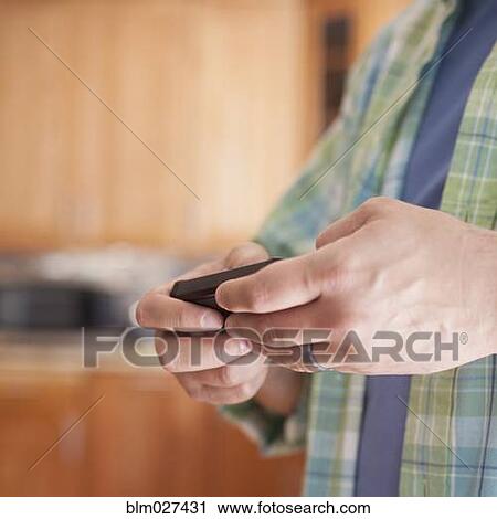 Stock Image - Pacific Islander man using cell phone. Fotosearch