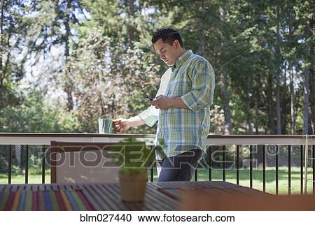 Stock Image - Pacific Islander man using cell phone. Fotosearch