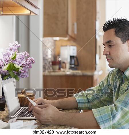 Stock Photo - Pacific Islander man using laptop. Fotosearch