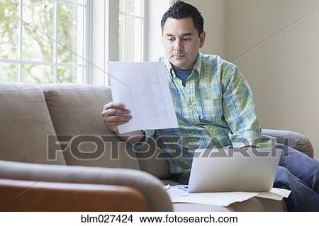 Picture - Pacific Islander man working on sofa. Fotosearch