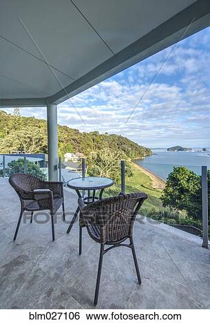 Table and chairs on balcony overlooking Bay of Islands, Paihia, New Zealand View Large Photo Image Stock Photograph - Table and chairs on balcony overlooking Bay of Islands, Paihia, New Zealand. Fotosearch