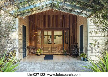 Stock Image - Vines growing over hotel entrance. Fotosearch
