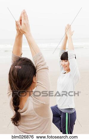 Women practicing yoga on beach View Large Photo Image Stock Photograph - Women practicing yoga on beach. Fotosearch