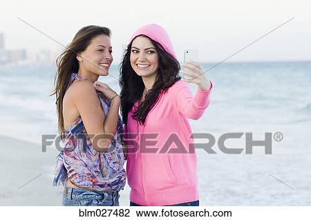 Women taking pictures together on beach View Large Photo Image Stock Image - Women taking pictures together on beach. Fotosearch