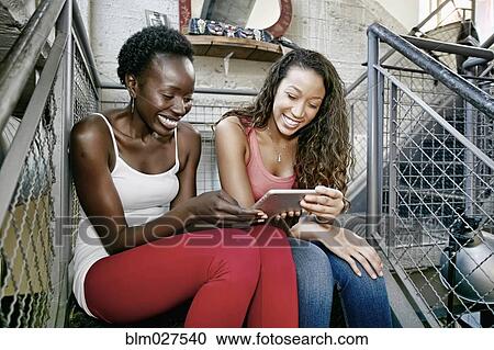 Women using digital tablet on steps View Large Photo Image Stock Image - Women using digital tablet on steps. Fotosearch