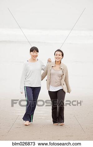 Women walking on beach View Large Photo Image Stock Image - Women walking on beach. Fotosearch