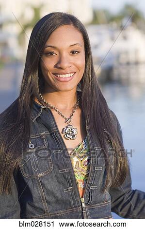 Stock Image - African American woman smiling outdoors. Fotosearch