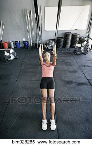 Stock Photography - African American woman working out in gym. Fotosearch