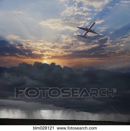 Stock Image - Airplane flying in dramatic sky. Fotosearch