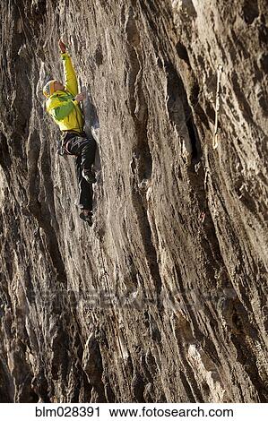 Asian climber scaling steep cliff face View Large Photo Image Stock Image - Asian climber scaling steep cliff face. Fotosearch
