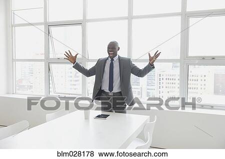Black businessman cheering in office View Large Photo Image Stock Photo - Black businessman cheering in office. Fotosearch