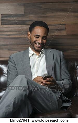 Black businessman using cell phone in office View Large Photo Image Stock Image - Black businessman using cell phone in office. Fotosearch