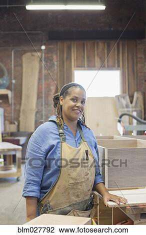 Stock Image - Black carpenter in workshop. Fotosearch