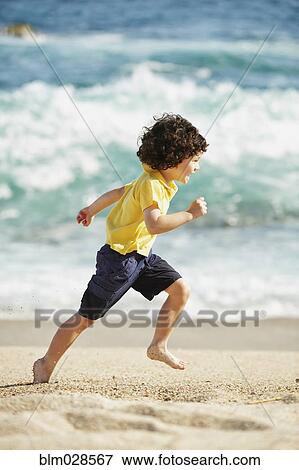 Boy running on beach View Large Photo Image Stock Photo - Boy running on beach. Fotosearch