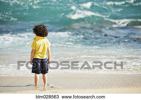 Boy standing on beach View Large Photo Image Stock Image - Boy standing on beach. Fotosearch