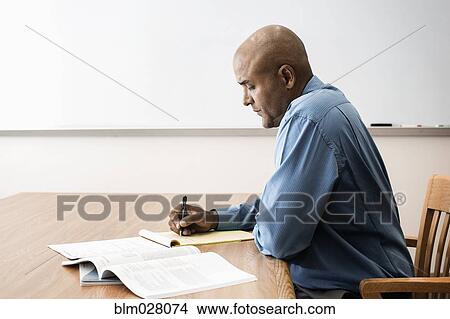 Picture - Businessman making notes in office. Fotosearch