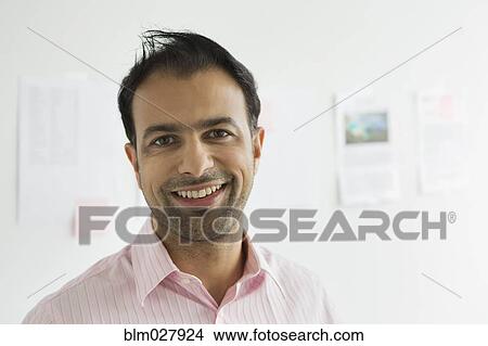 Picture - Businessman smiling in office. Fotosearch