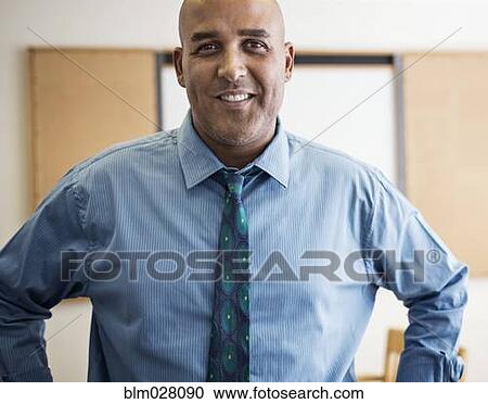 Stock Image - Businessman smiling in office. Fotosearch