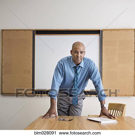 Stock Image - Businessman standing in office. Fotosearch