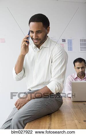 Businessman talking on telephone in office View Large Photo Image Stock Image - Businessman talking on telephone in office. Fotosearch