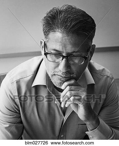 Stock Photograph - Businessman thinking in office. Fotosearch