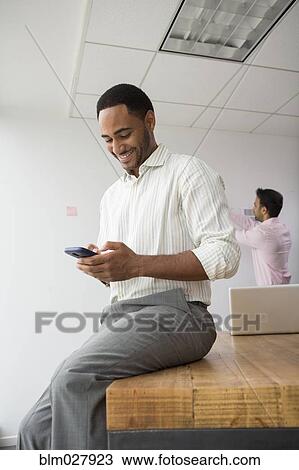 Businessman using cell phone in office View Large Photo Image Stock Image - Businessman using cell phone in office. Fotosearch