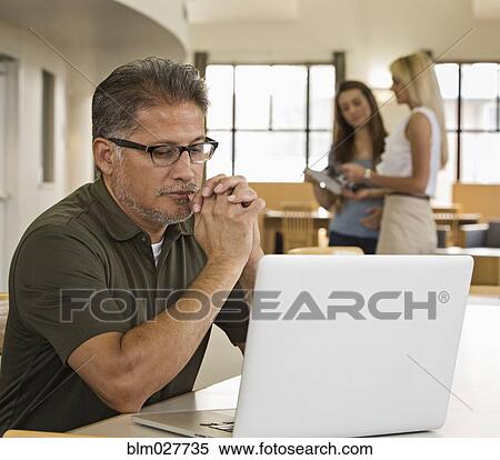 Businessman working at laptop View Large Photo Image Stock Photography - Businessman working at laptop. Fotosearch
