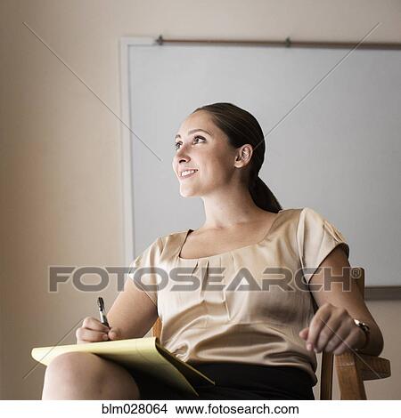 Businesswoman making notes in office View Large Photo Image Picture - Businesswoman making notes in office. Fotosearch