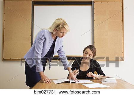 Businesswoman reviewing paperwork in conference room View Large Photo Image Stock Image - Businesswoman reviewing paperwork in conference room. Fotosearch