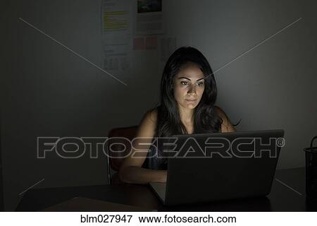 Businesswoman working at laptop at night View Large Photo Image Stock Photo - Businesswoman working at laptop at night. Fotosearch