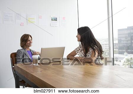 Businesswomen talking in office View Large Photo Image Stock Image - Businesswomen talking in office. Fotosearch