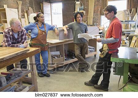 Carpenters discussing paperwork in workshop View Large Photo Image Stock Photo - Carpenters discussing paperwork in workshop. Fotosearch
